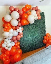 an orange and white balloon arch in a living room