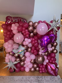 a pink and gold balloon wall in a living room
