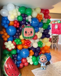 a balloon wall decorated with balloons and a teddy bear